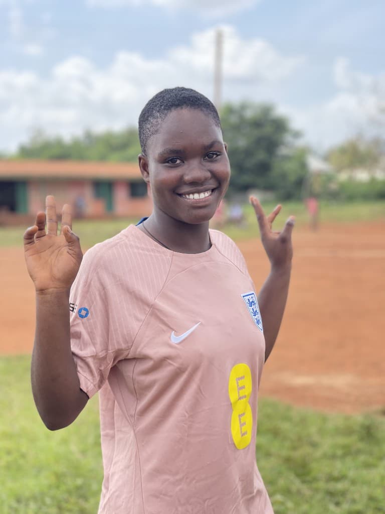 Akosua Boateng smiling in her football kit at school